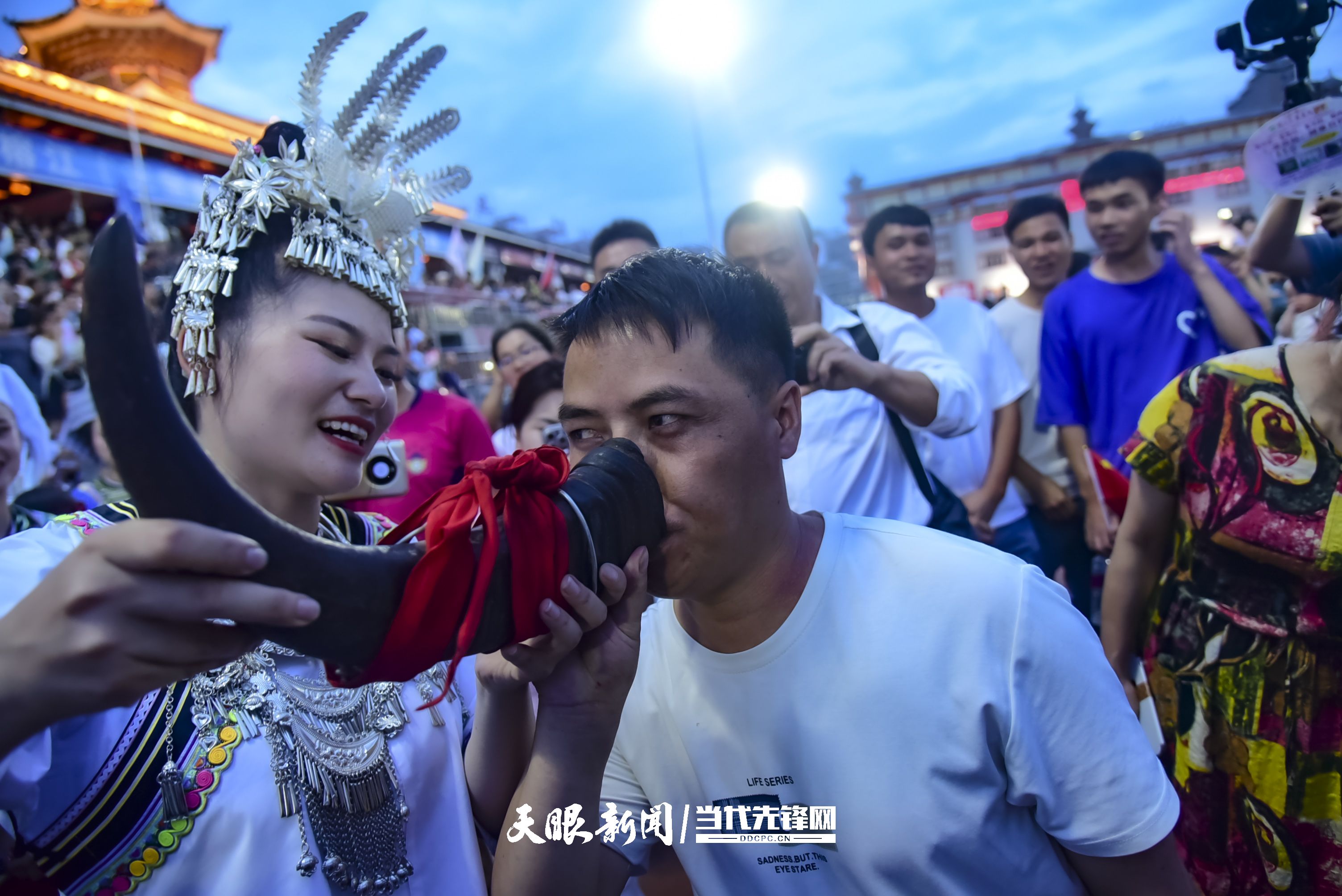 村超現(xiàn)場，當(dāng)?shù)厝罕娤蜻h(yuǎn)道而來的游客敬酒。 潘邵平 攝.jpg
